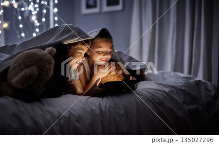 Night, tablet and siblings in bed, home or watching a movie, film or cartoon with happiness. Children, kids or brother with sister, technology or online games with a smile, dark or relax in a bedroom Night, tablet and siblings in bed, home or watching a movie, film or cartoon with happiness. Children, kids or brother with sister, technology or online games with a smile, dark or relax in a bedroom 135027296