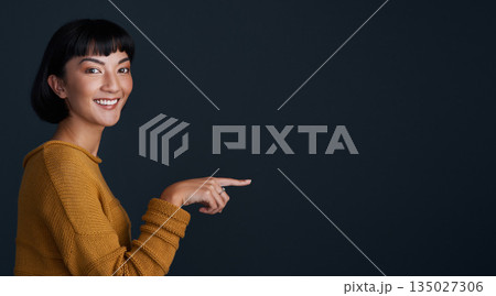 Woman is pointing, marketing and mockup space with portrait, smile and promo isolated on dark background. Young female person, happy ambassador and branding with advertising and show in studio Woman is pointing, marketing and mockup space with portrait, smile and promo isolated on dark background. Young female person, happy ambassador and branding with advertising and show in studio 135027306