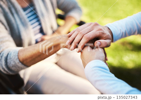 Senior woman, caregiver and holding hands in support care or love for healthcare or life insurance in nature. Hand of nurse helping or nursing mature patient in wheelchair or person with a disability 135027343
