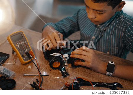 Education, car robot and top view of child with homework, homeschool and science, learning and tech project. Robotics, building and boy kid with electrical knowledge, engineering or studying in house Education, car robot and top view of child with homework, homeschool and science, learning and tech project. Robotics, building and boy kid with electrical knowledge, engineering or studying in house 135027382