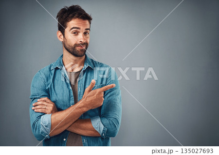 Portrait, pointing and man with mockup, promotion and opportunity against a grey studio background. Face, male person and model with casual outfit, decision and choice with happiness and showing Portrait, pointing and man with mockup, promotion and opportunity against a grey studio background. Face, male person and model with casual outfit, decision and choice with happiness and showing 135027693