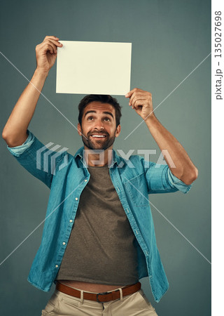 Happy man, poster and mockup billboard for advertising, marketing or branding against a grey studio background. Male person holding blank shape placard or board for sign, message or advertisement 135027698