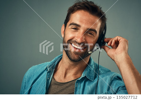 Happy man, headphones and portrait of call center consultant against a grey studio background. Face of friendly male consulting agent with smile and headset in contact us for help or online advice Happy man, headphones and portrait of call center consultant against a grey studio background. Face of friendly male consulting agent with smile and headset in contact us for help or online advice 135027712