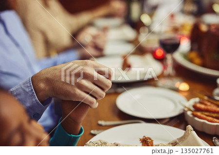 Prayer, Christmas and hand holding with family at table in dining room for holiday, food or worship. Celebration, support and gratitude with closeup of people at home for kindness, dinner and love Prayer, Christmas and hand holding with family at table in dining room for holiday, food or worship. Celebration, support and gratitude with closeup of people at home for kindness, dinner and love 135027761