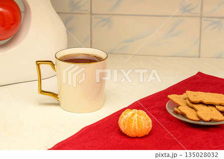 cup of tea with cookies and tangerine on the kitchen table cup of tea with cookies and tangerine on the kitchen table 135028032