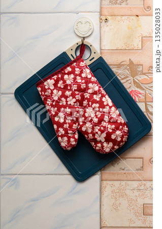 kitchen mitten lies on a cutting board on the wall kitchen mitten lies on a cutting board on the wall 135028033