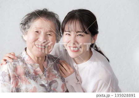 孫と祖母の笑顔の寄り添うポートレート　カメラ目線のクローズアップ 135028891