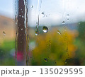 Raindrops on a window pane with a soft, colorful b 135029595