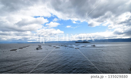 福井県の若狭湾の穏やかな海面に浮かぶ養殖筏と雲の広がる美しい空の風景 135029880