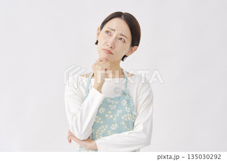 エプロンを着た女性　悩む　白背景 135030292