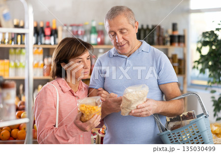 Couple elderly man and woman choosing flakes in grocery store 135030499