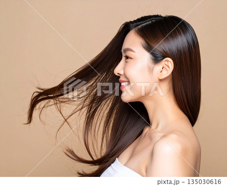 長い髪をなびかせるヘアモデルの女性　横顔　笑顔　ロングヘア 135030616