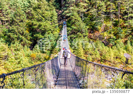 Suspension bridge over deep gorge in Himalayan mountains, Nepal. 135030877