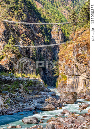 Suspension bridge over deep gorge in Himalayan mountains, Nepal. 135030878