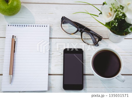 Flat design wooden desk workspace is showing notebook, pen, apple, smartphone, coffee mug Flat design wooden desk workspace is showing notebook, pen, apple, smartphone, coffee mug 135031571