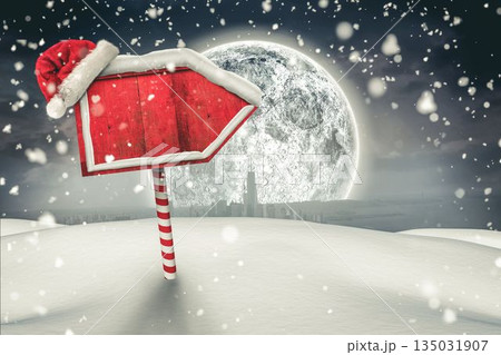 Flat design red arrow sign is standing on striped pole wearing Santa hat, snowfall, moonlit skyline 135031907