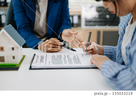 Real estate broker agent presenting and consult to customer to decision making sign insurance form agreement, home model Real estate broker agent presenting and consult to customer to decision making sign insurance form agreement, home model 135033219