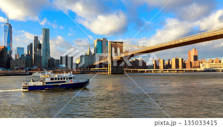 Brooklyn Bridge seen from boat in New York with city skyline 135033415