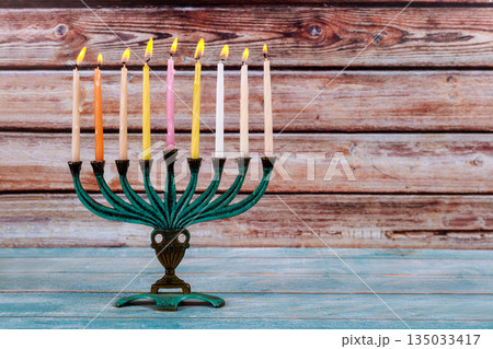 Beautifully lit menorah with candles glowing Hanukkah event celebration during Jewish festive 135033417