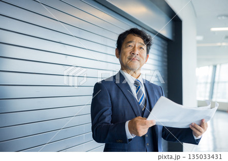 店舗物件の前で考えるビジネスマン 135033431