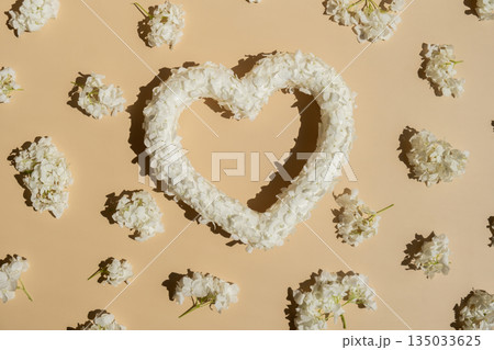 Symbol of love beautiful flower petals in heart shape in beige background. Creative concept of St Valentines day, weeding romantic date or anniversary. Copy space 135033625