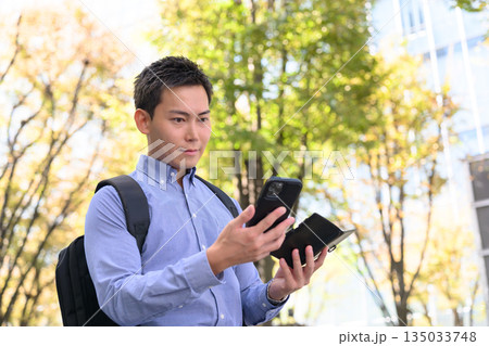 屋外でスマホを見る男性 屋外でスマホを見る男性 135033748