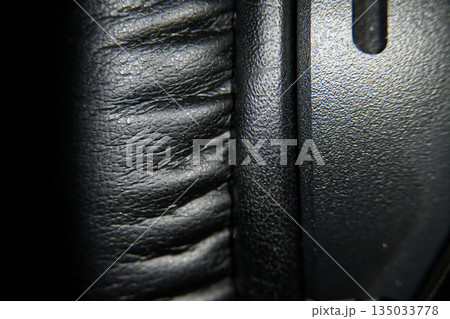 Close-up macro shot of black leather headphone earcups showing texture and detail 135033778