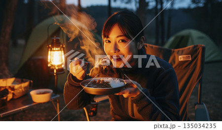 キャンプでカレーライスを食べる女性 135034235