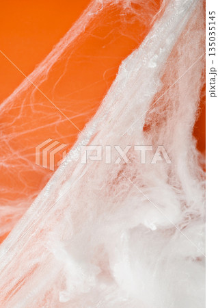 Spooky Halloween decoration with white cobweb on an orange background. Mockup, copy space, or template. Perfect for creating a festive atmosphere for Halloween parties or spooky projects Spooky Halloween decoration with white cobweb on an orange background. Mockup, copy space, or template. Perfect for creating a festive atmosphere for Halloween parties or spooky projects 135035145