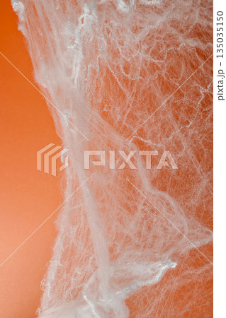 Spooky Halloween decoration with white cobweb on an orange background. Mockup, copy space, or template. Perfect for creating a festive atmosphere for Halloween parties or spooky projects Spooky Halloween decoration with white cobweb on an orange background. Mockup, copy space, or template. Perfect for creating a festive atmosphere for Halloween parties or spooky projects 135035150