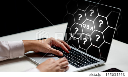 Person uses a laptop with a question and answer graphic displayed on the screen. Concept of Questions and Answers Person uses a laptop with a question and answer graphic displayed on the screen. Concept of Questions and Answers 135035268
