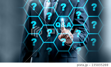 Businessman in a suit touching a digital screen with a Q and A button surrounded by question marks. Concept for questions and answers, online support, and information Businessman in a suit touching a digital screen with a Q and A button surrounded by question marks. Concept for questions and answers, online support, and information 135035269