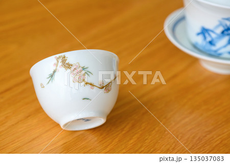 日本茶の湯飲みまたは台湾茶、中国茶の茶杯またはお酒の盃（斜め置きで正面から撮影　手描きの絵柄） 135037083