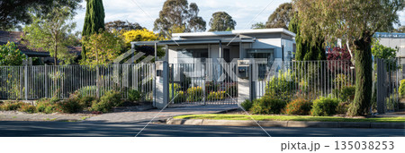 Modern fence showcases advanced facial recognition technology and smartphone-controlled access. The sleek metal panels reflect light in a residential setting, enhancing security and style, banner 135038253