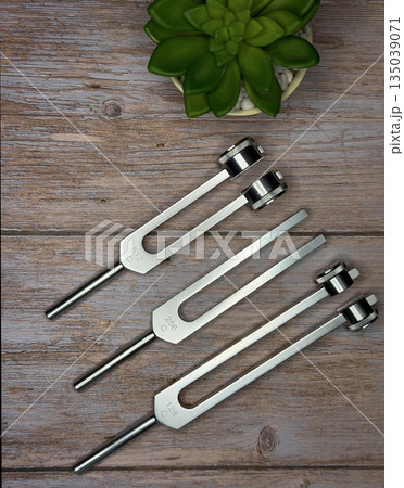 Set of Tuning Forks for Sound Therapy and Healing on Wooden Surface 135039071