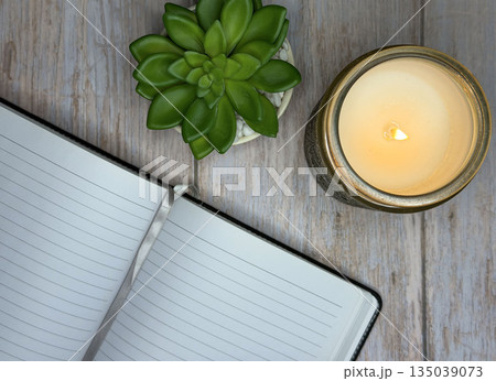 Calming Self Care Scene With Candle, Journal, and Plant on Wooden Surface 135039073