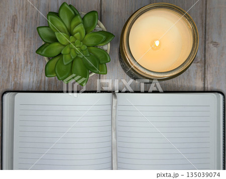 Calming Self Care Scene With Candle, Journal, and Plant on Wooden Surface 135039074