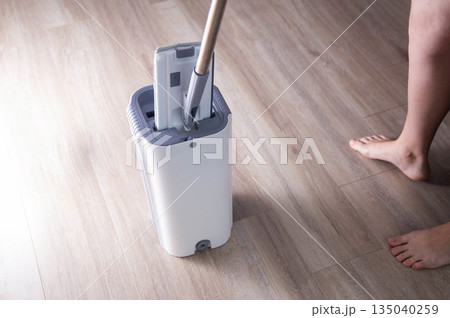 Washing and cleaning the room with a modern mop with a bucket and wringer. Modern novelty for cleaning. Copy space for text, industry 135040259