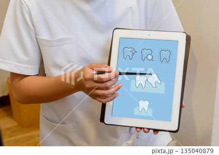 歯科医がタブレットで歯の状態を説明するシーン 歯科医がタブレットで歯の状態を説明するシーン 135040879