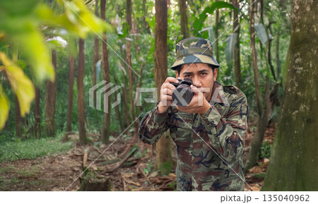 A man in a military uniform is capturing the beauty of nature with a DSLR camera. 135040962