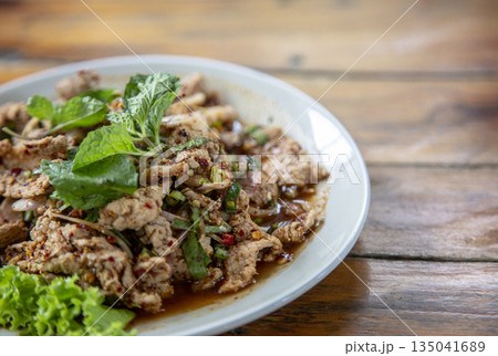 Spicy Thai Larb Moo: Fresh pork salad with a vibrant chili kick, served with refreshing mint. An authentic taste of Thailand 135041689