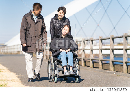 車椅子を押して散策をする親子 135041870