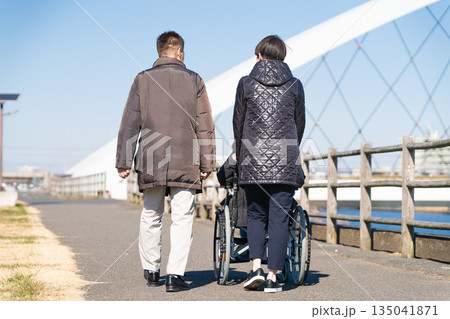車椅子を押して散策をする親子 車椅子を押して散策をする親子 135041871