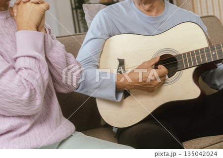 Happy Senior Couple Enjoying Retirement Together Playing Musical Instruments at Home in Bright Sunshine Happy Senior Couple Enjoying Retirement Together Playing Musical Instruments at Home in Bright Sunshine 135042024