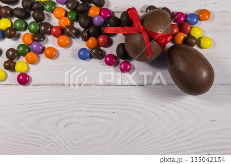 Easter composition with chocolate eggs on white wooden background 135042154