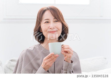 マグカップで飲み物を飲むシニア女性 135043128