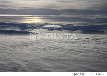 機内から望む海のように広がる白い雲海 135043657
