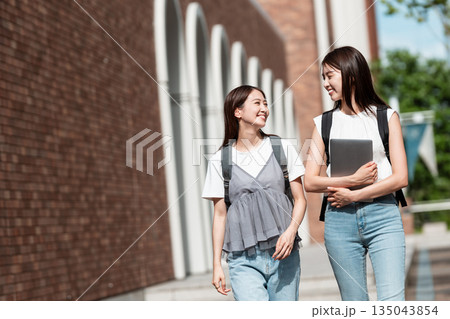 大学のキャンパス内を歩く女子大生 大学のキャンパス内を歩く女子大生 135043854
