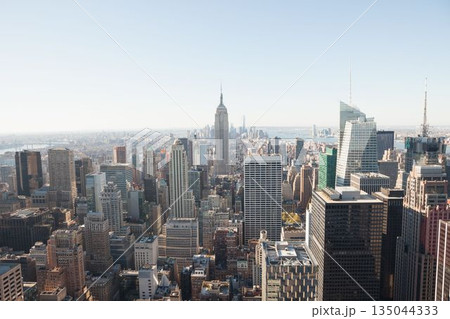 Midtown Manhattan skyline is being shown in flat design with Empire State Building, rooftop tanks Midtown Manhattan skyline is being shown in flat design with Empire State Building, rooftop tanks 135044333