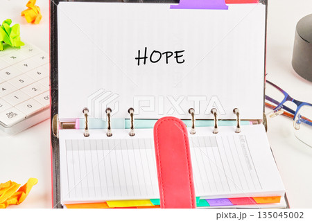 An open journal displays the word HOPE written in bold letters An open journal displays the word HOPE written in bold letters 135045002